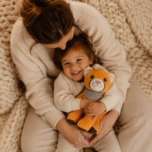 Mother and her child cuddling with Lenabie plush toy Tali (a cuddly friend in a Puma motif)