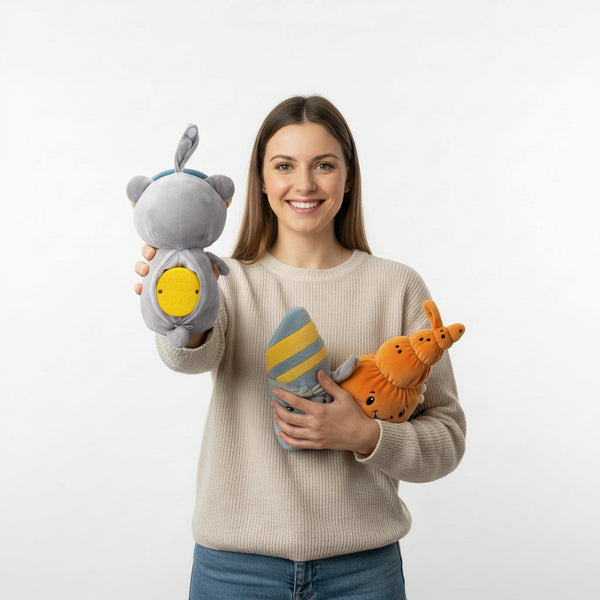 Produktbild zeigt den eingesetzten Lenabo Smart Speaker in der Innentasche eines Lenabo Kuscheltieres (Lenabie Aaron) sowie weitere Lenabies auf dem Arm einer Mutter zum einfachen Motivwechsel; kleines und kompaktes Audiomodul passend für alle Lenabo Plüschcharaktere, nutzbar ab Geburt (0 Jahre) mit altersgerechten Audioinhalten von Weißem Rauschen und Einschlafmelodien bis zu Hörspielen, Geschichten und Lerninhalten für Babys, Kleinkinder, Kindergarten- und Grundschulkinder